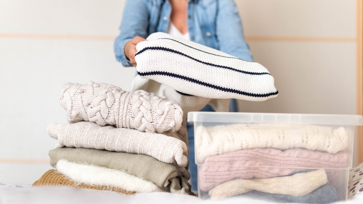 Donna mette i maglioni nella scatola